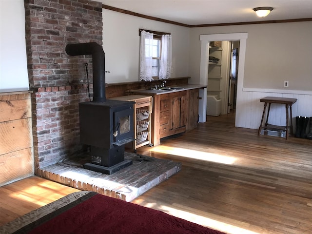 bar featuring a wood stove, crown molding, and dark hardwood / wood-style floors