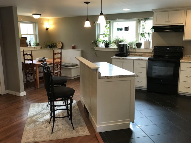 kitchen featuring hanging light fixtures, a kitchen island, range hood, black electric range, and white cabinets