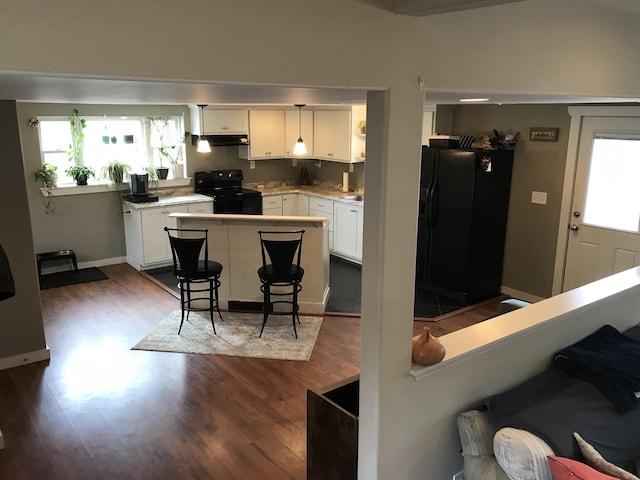 kitchen featuring a wealth of natural light, white cabinets, dark hardwood / wood-style floors, and black appliances