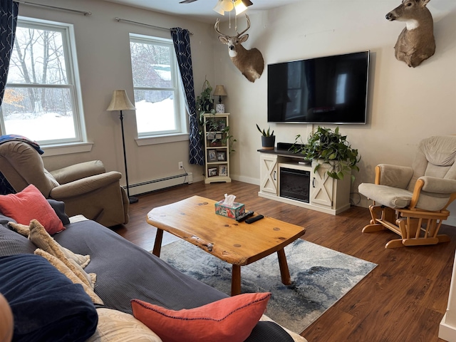 living room with baseboard heating, ceiling fan, and dark hardwood / wood-style floors