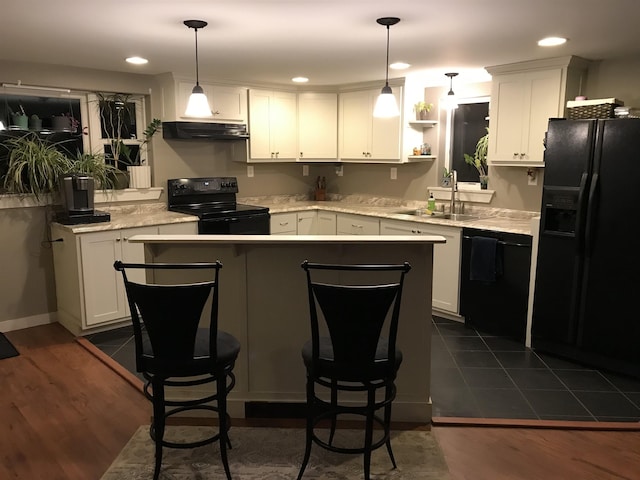 kitchen with decorative light fixtures, white cabinetry, and black appliances