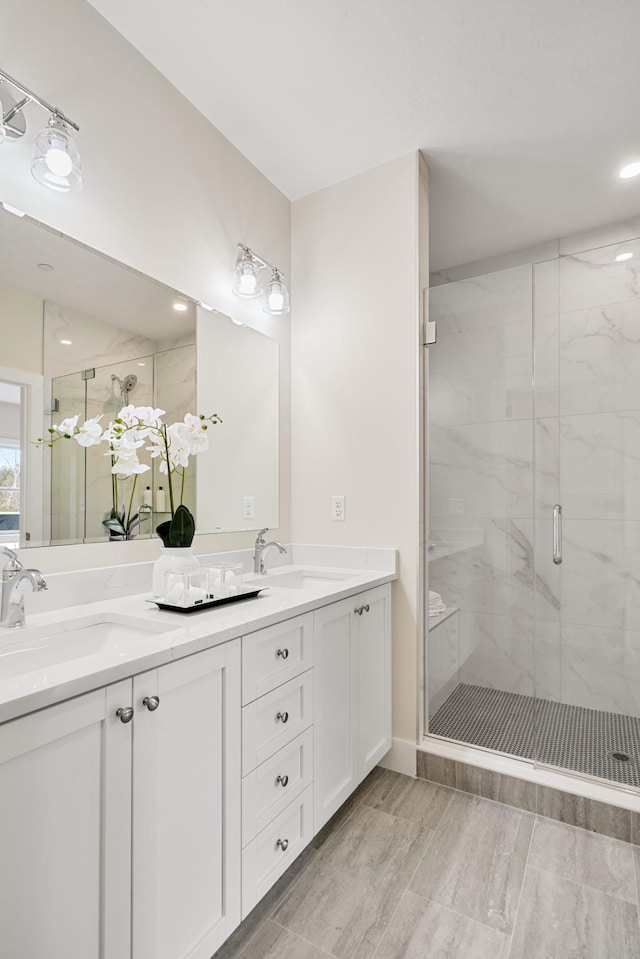 bathroom with vanity and a shower with door