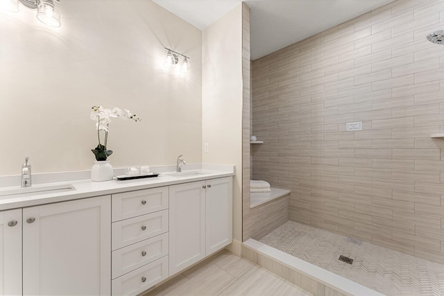 bathroom featuring a tile shower, vanity, and tile patterned floors