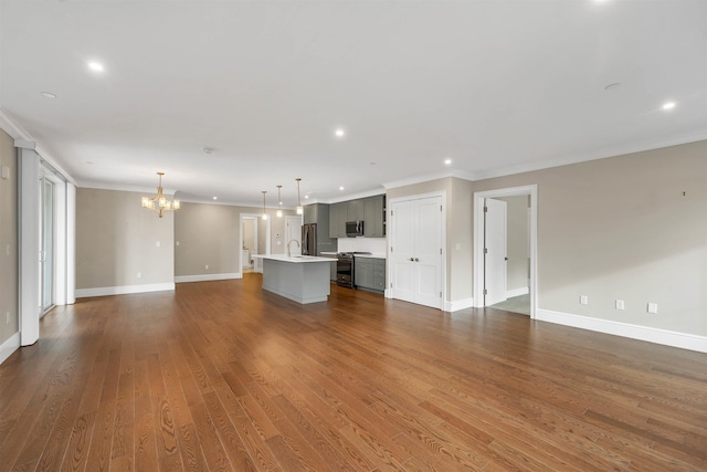 unfurnished living room featuring dark hardwood / wood-style flooring, crown molding, and a notable chandelier