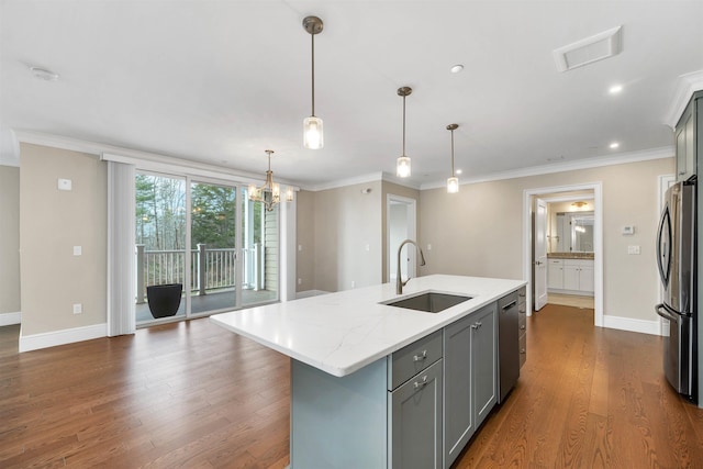 kitchen with pendant lighting, gray cabinetry, a center island with sink, sink, and appliances with stainless steel finishes