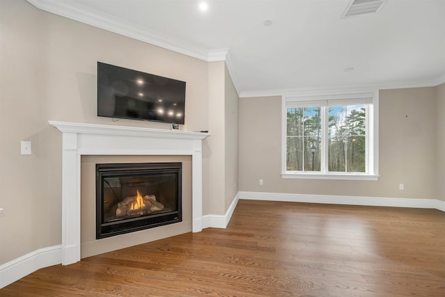 unfurnished living room with hardwood / wood-style flooring and crown molding