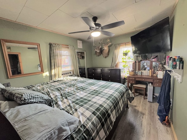 bedroom featuring ceiling fan, ornamental molding, and hardwood / wood-style flooring