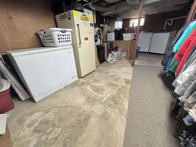 basement with washer and dryer, refrigerator, and white fridge