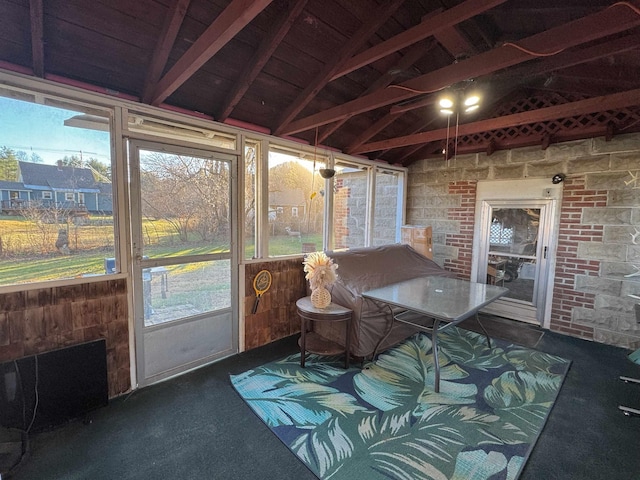 sunroom / solarium featuring lofted ceiling with beams