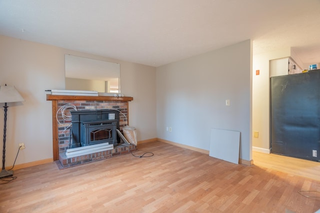 living room featuring a wood stove and light hardwood / wood-style floors