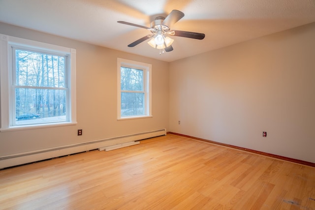 empty room with light wood-type flooring, ceiling fan, and a baseboard heating unit