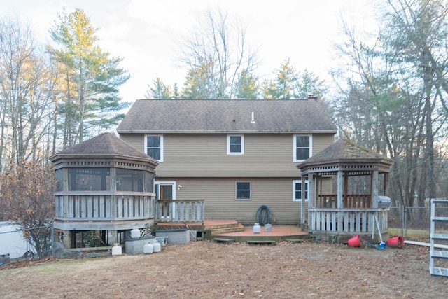 back of house featuring a gazebo, a sunroom, and a wooden deck