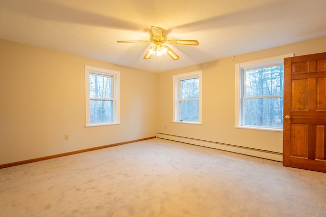 carpeted empty room with ceiling fan and a baseboard heating unit