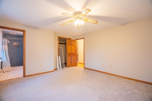 unfurnished bedroom featuring ceiling fan, a walk in closet, and light carpet