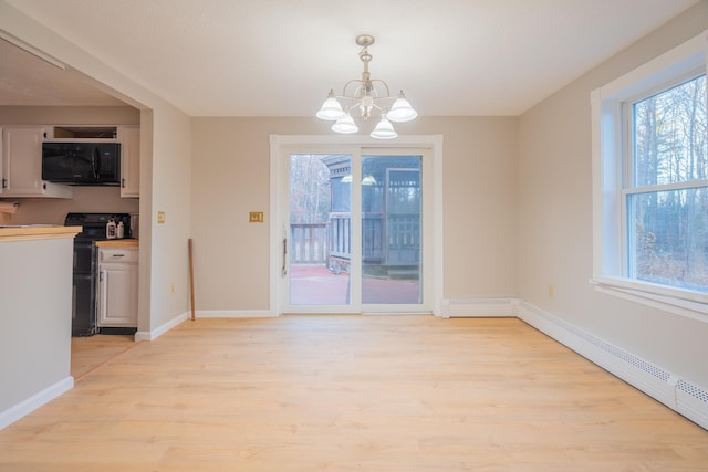 unfurnished dining area with light hardwood / wood-style floors, a baseboard heating unit, and a notable chandelier