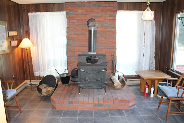 room details featuring a wood stove, baseboard heating, and wooden walls