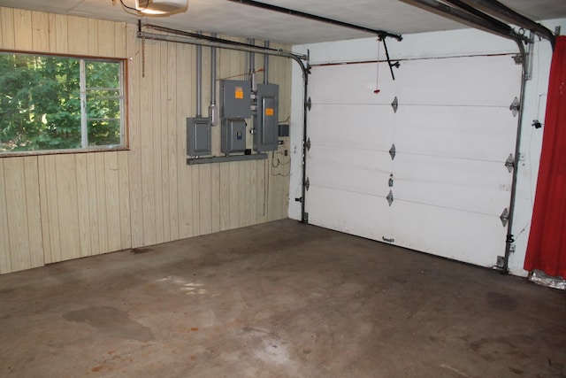 garage with electric panel, wood walls, and a garage door opener