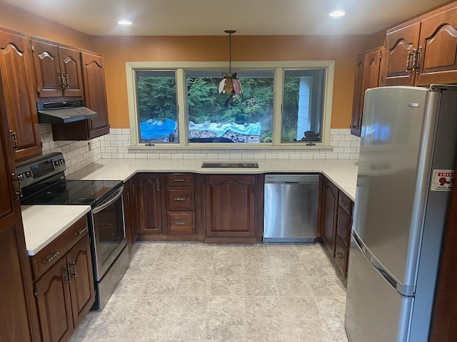 kitchen featuring decorative backsplash, appliances with stainless steel finishes, and decorative light fixtures