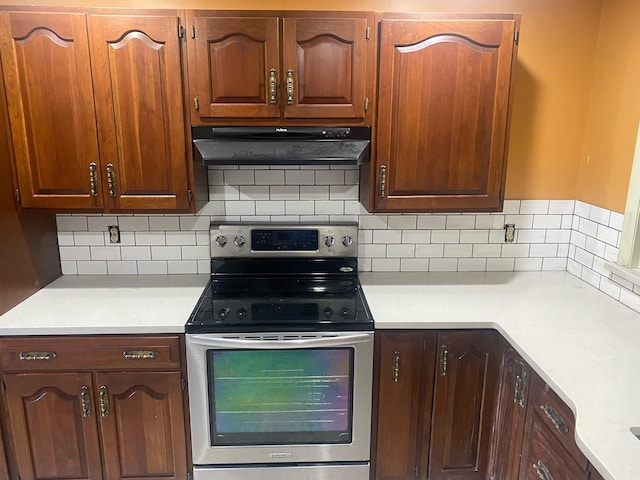 kitchen with stainless steel electric stove and backsplash