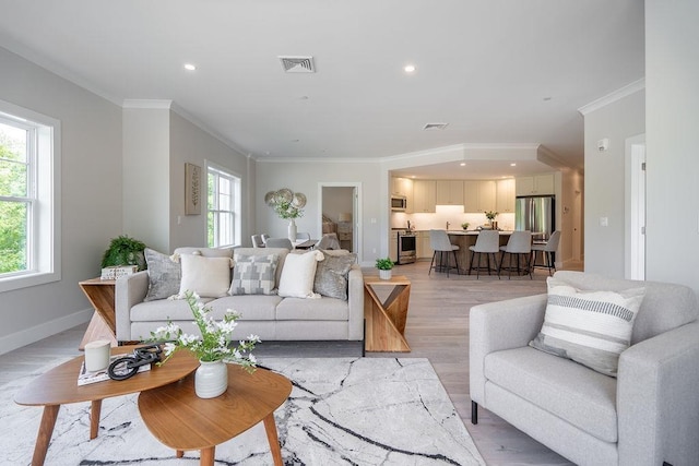 living room featuring ornamental molding and light hardwood / wood-style flooring