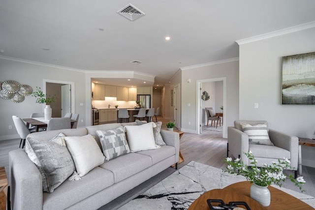 living room with light wood-type flooring and ornamental molding