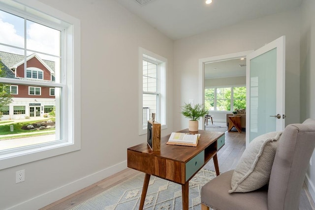 home office with light hardwood / wood-style flooring