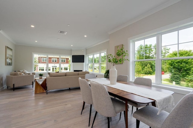 dining area with light hardwood / wood-style flooring, plenty of natural light, and crown molding