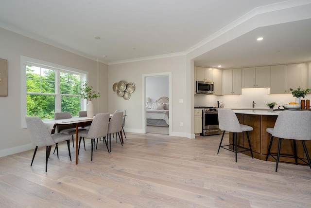 dining area with light wood-type flooring and crown molding