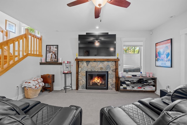 living room with carpet, ceiling fan, and a fireplace