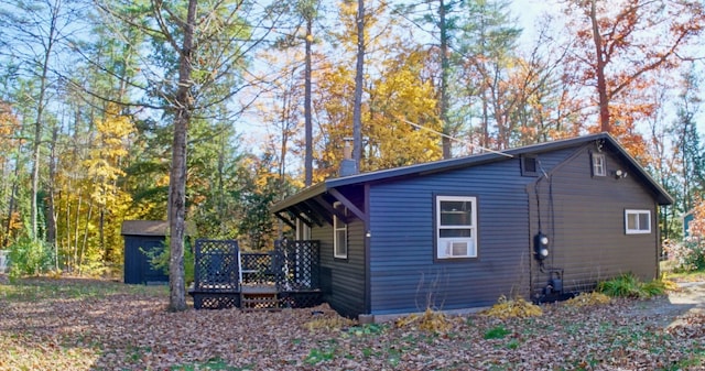 view of side of home with a storage unit and a wooden deck