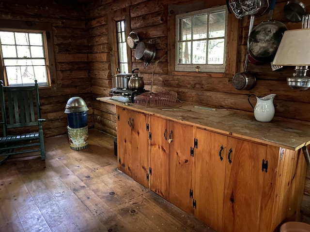 interior space with log walls and hardwood / wood-style flooring