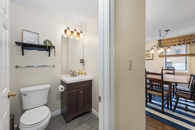 bathroom featuring hardwood / wood-style floors, vanity, toilet, and a textured ceiling