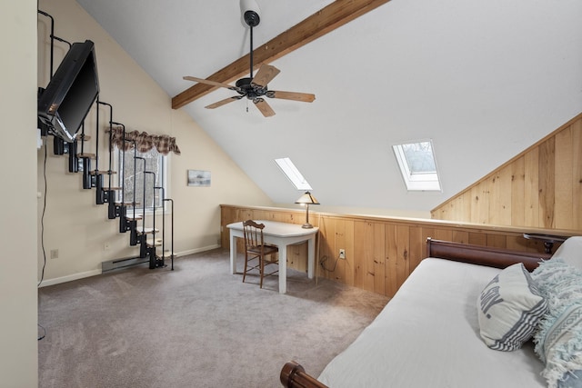 carpeted bedroom featuring vaulted ceiling with skylight and wood walls