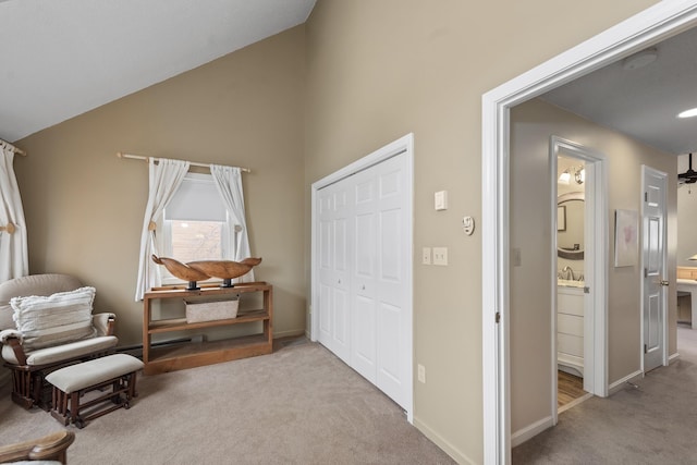 sitting room featuring sink, lofted ceiling, and light carpet