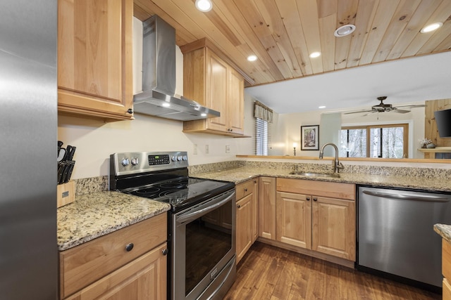 kitchen featuring appliances with stainless steel finishes, light brown cabinetry, wall chimney exhaust hood, ceiling fan, and sink