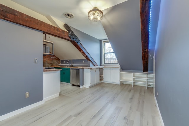 kitchen with white cabinets, vaulted ceiling, dishwasher, tasteful backsplash, and light hardwood / wood-style flooring