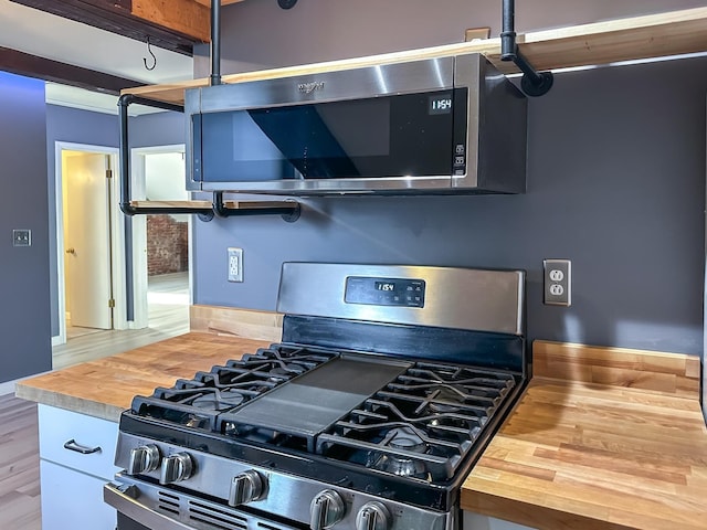 kitchen featuring appliances with stainless steel finishes, wooden counters, and hardwood / wood-style flooring