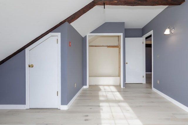 additional living space with light wood-type flooring and vaulted ceiling