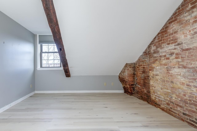 bonus room featuring brick wall, light wood-type flooring, and lofted ceiling with beams