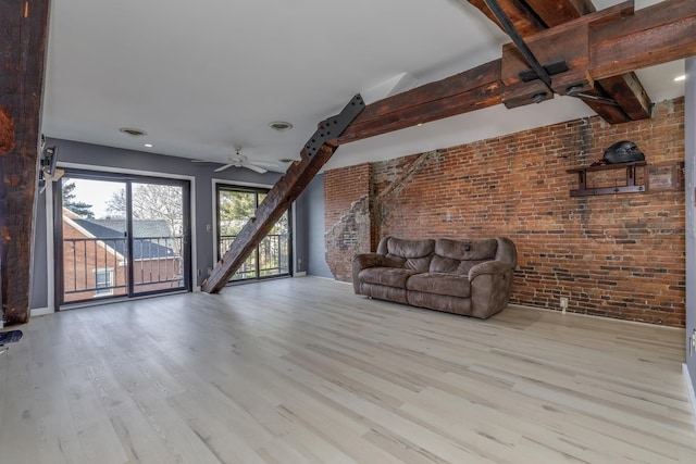 unfurnished living room featuring brick wall, light wood-type flooring, ceiling fan, and beam ceiling