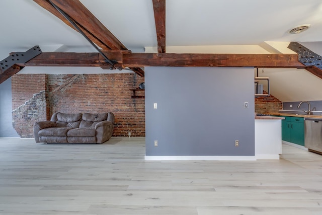 unfurnished living room featuring brick wall, light hardwood / wood-style floors, beamed ceiling, and sink