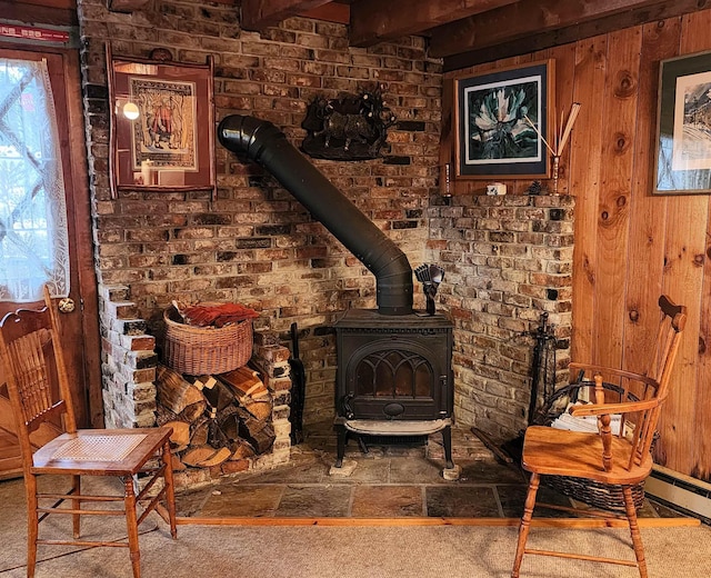 interior space with wood walls, a wood stove, and carpet floors