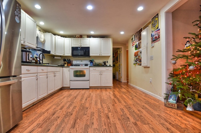 kitchen featuring white cabinets, sink, light hardwood / wood-style flooring, electric range, and stainless steel refrigerator