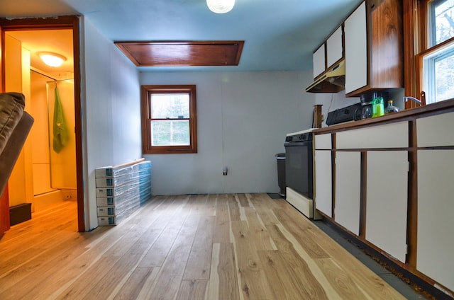 kitchen featuring white cabinetry, light hardwood / wood-style flooring, and white stove