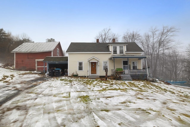 view of front of property featuring a porch, a garage, and an outdoor structure