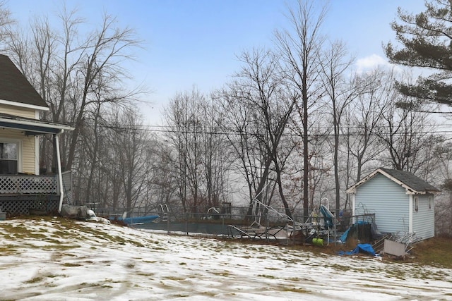 yard covered in snow featuring a pool