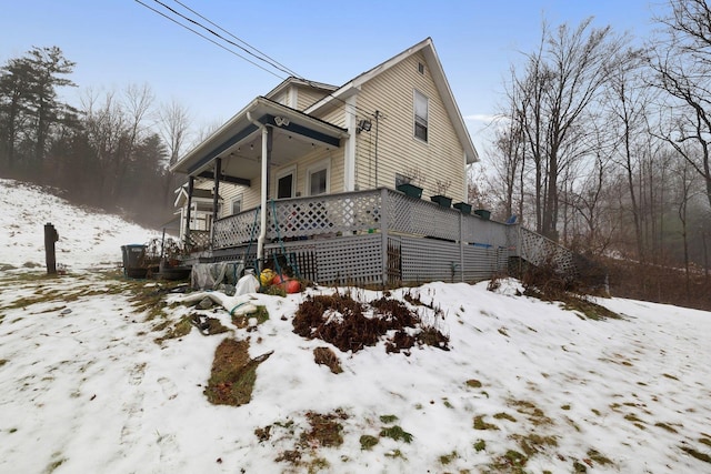 view of snowy exterior featuring covered porch