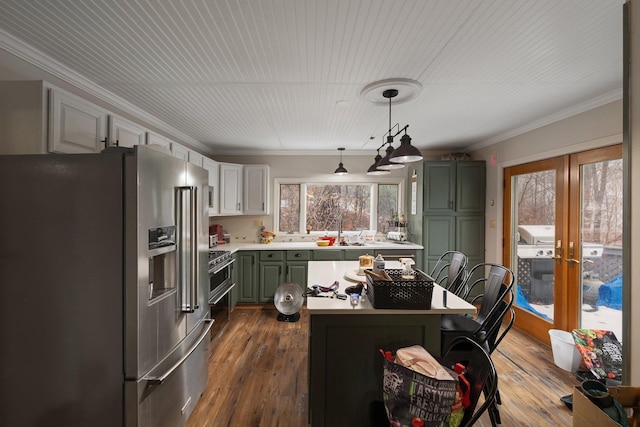 kitchen featuring pendant lighting, dark wood-type flooring, crown molding, green cabinetry, and high end fridge