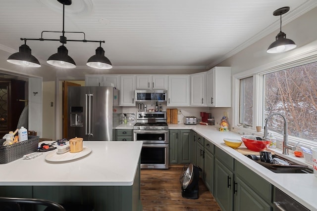 kitchen featuring pendant lighting, sink, dark hardwood / wood-style flooring, white cabinetry, and stainless steel appliances