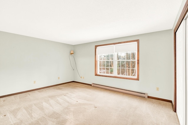 unfurnished bedroom with light carpet and a baseboard radiator